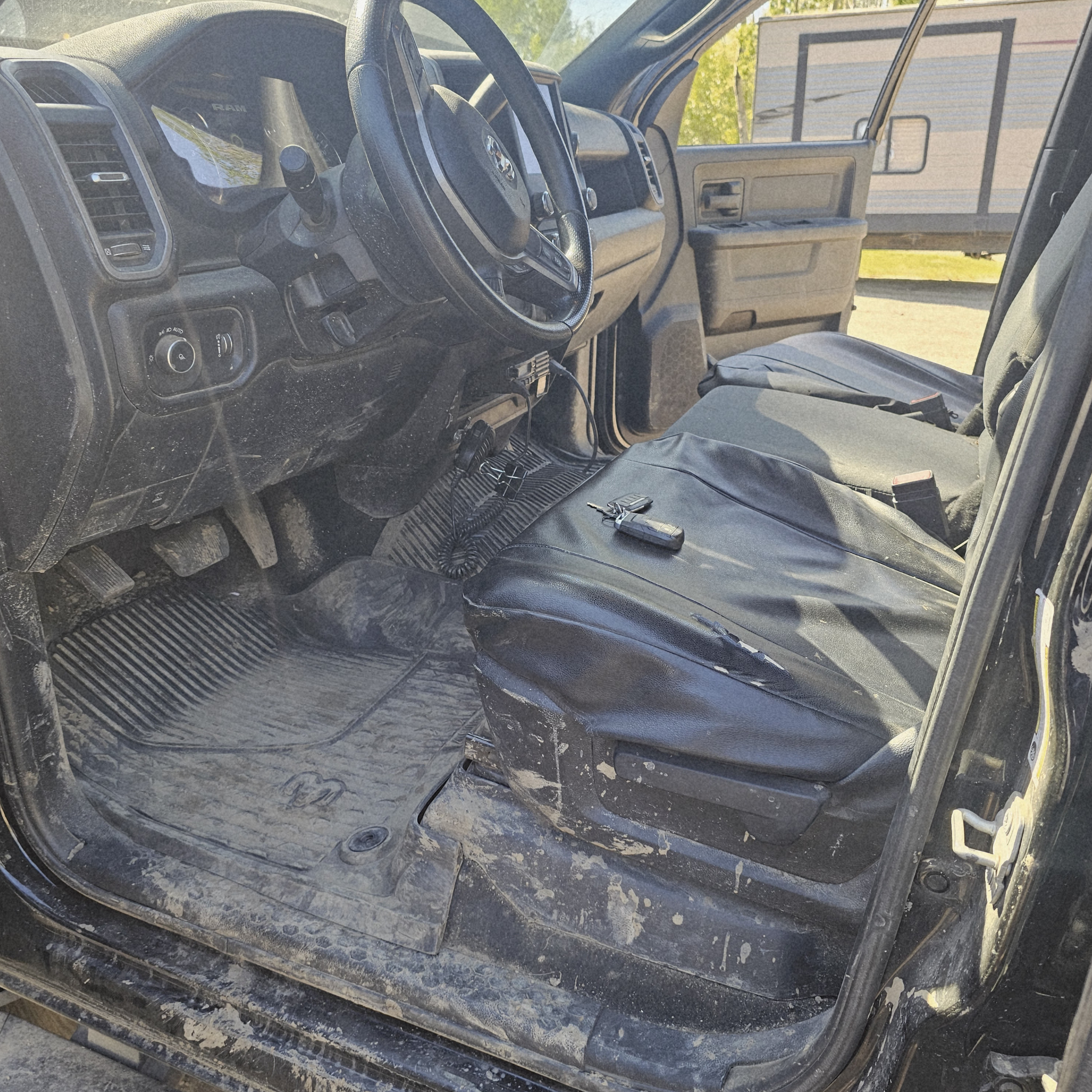 Dirty Ram 2500 work truck interior showing mud, dust, floor mats, seats, and door sills before professional detailing.