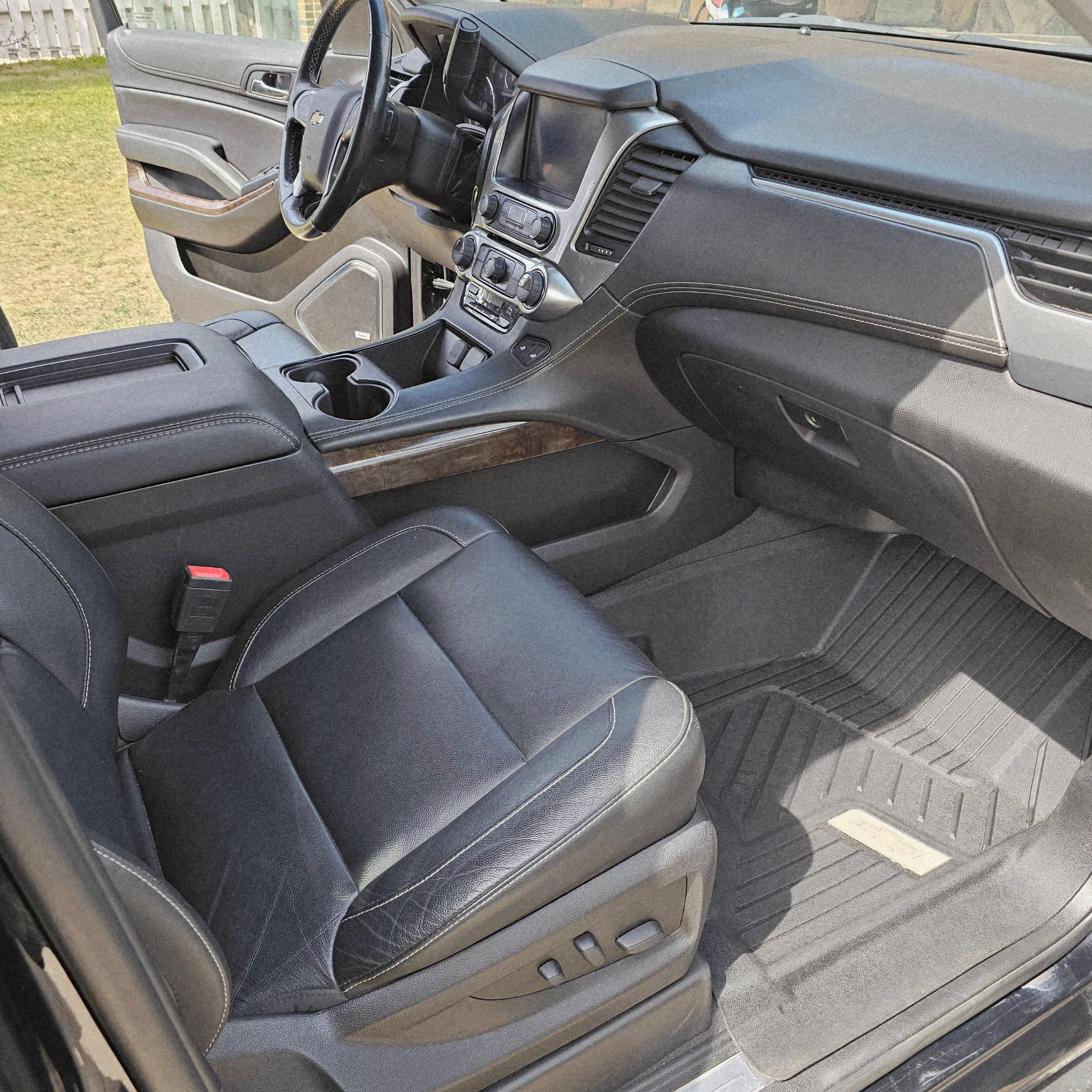 Clean Chevrolet Suburban interior featuring detailed leather seats, dashboard, center console, floor mats, and passenger area after professional detailing.