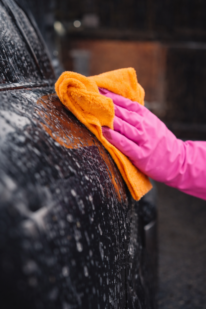 Professional mobile auto detailing technician hand washing a vehicle with microfiber towel in Dawson Creek BC.