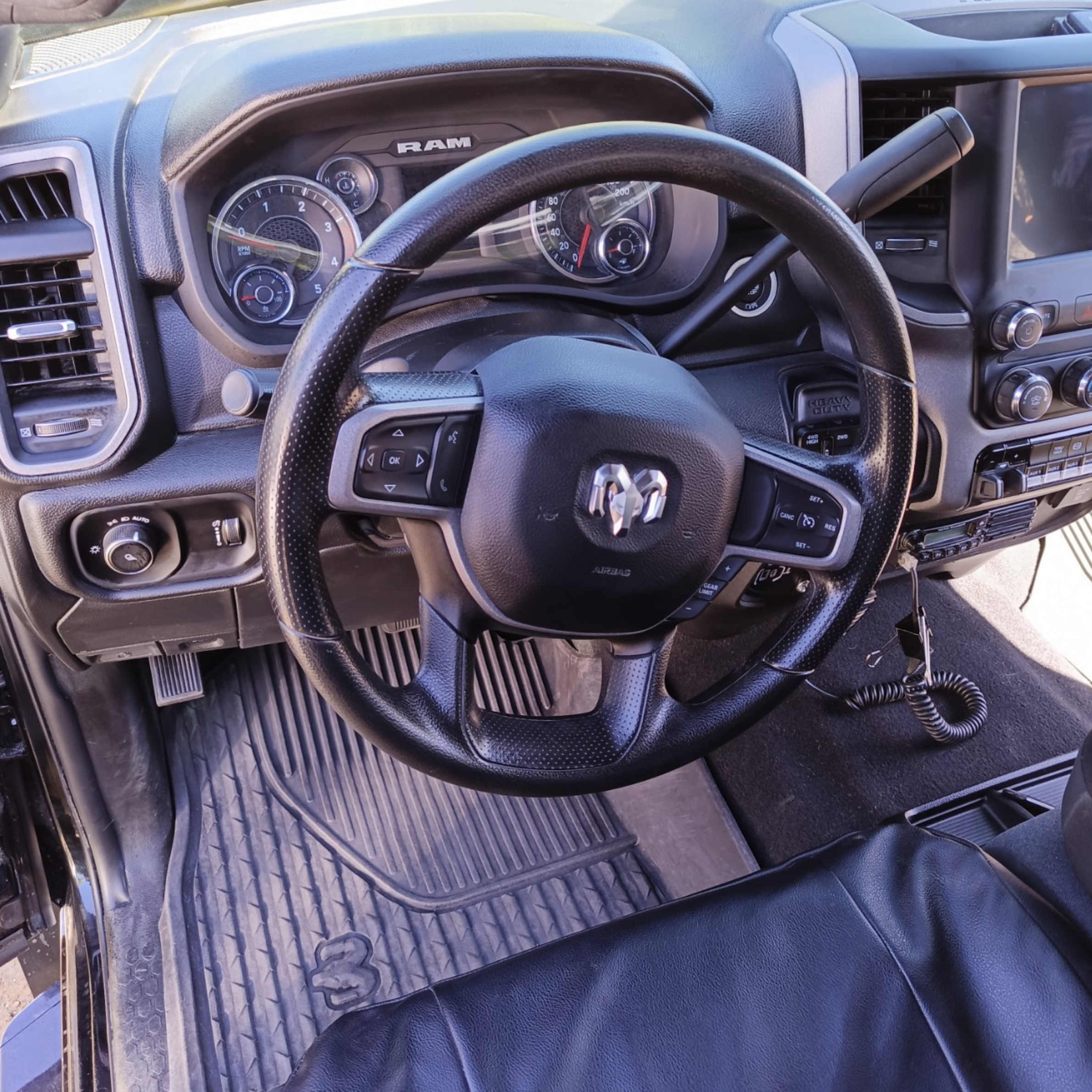 Clean Ram 2500 driver area showing detailed steering wheel, dashboard, floor mat, and interior surfaces after professional detailing.