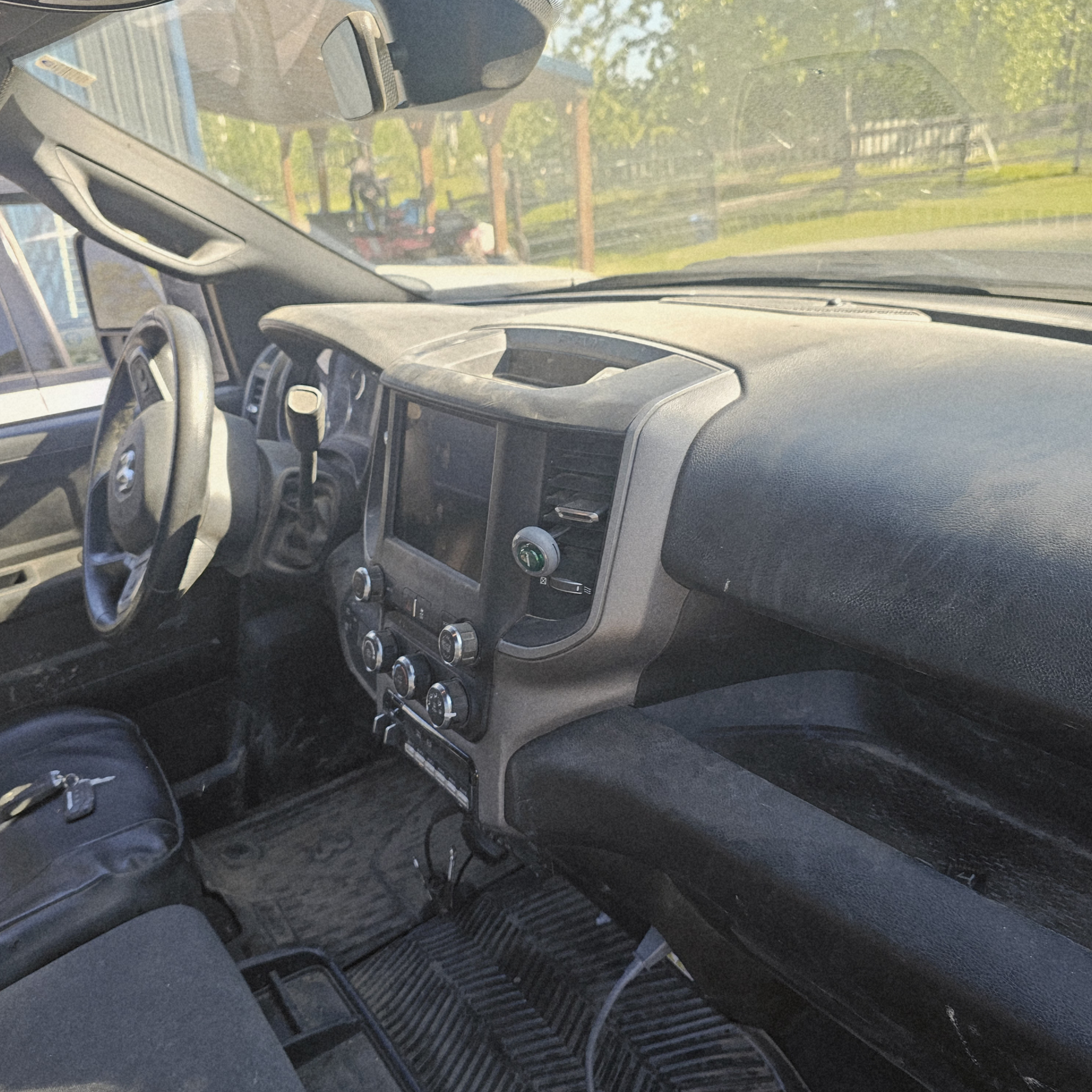 Dusty Ram 2500 dashboard, center console, seats, and floor mats before professional interior detailing service.